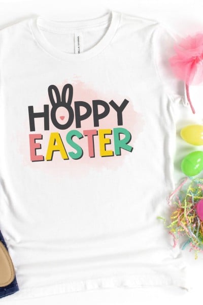 A pair of dark leggings, sandals, Easter eggs, pink headband and a white t-shirt that says Hoppy Easter